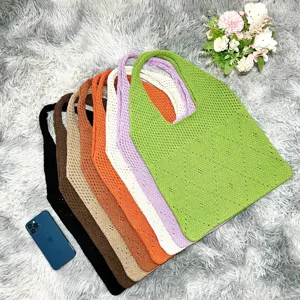 Detailansicht bunter Strick-Tote-Bag ordentlich auf flauschigem Teppich, stilvoll und leger.