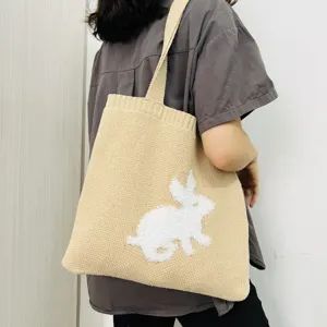 Beige gebreide shopper tas met schattig pluizig wit konijnenpatroon voor mode dames.