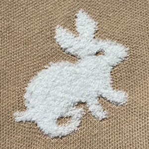Close-up detail van een schattig pluizig wit konijnen breipatroon op het oppervlak van stof.