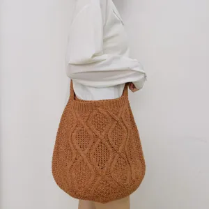 Detailaufnahme der braunen Strick-Schultertasche mit ihrer strukturierten Webmuster.