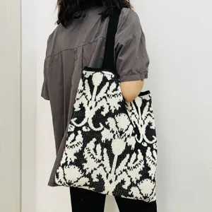 Gestrickte Blumentasche für Damen, schwarz-weiße Schultertasche mit modischem Webmuster.