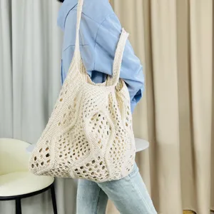 Nahaufnahme der beige gestrickten Loch-Tragetasche, zeigt Textur und Strandtaschenstil.