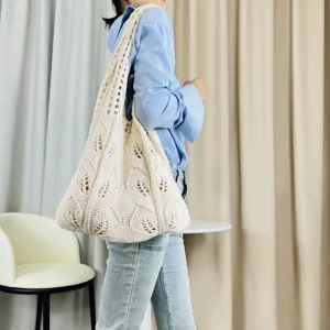 Detailansicht einer beige geflochtenen Strick-Schultertasche mit elegantem Hohl-Blumenmuster.