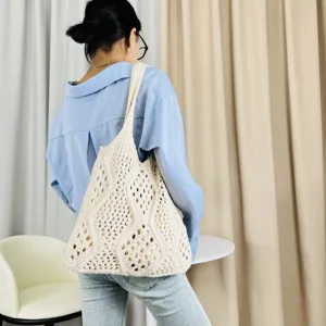 Detailansicht der beigen Strick-Häkel-Tasche, stylische Strand-Schultertasche am Model.