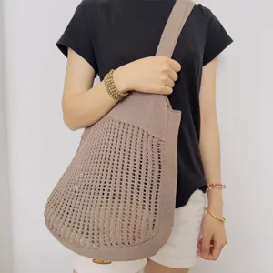 Nahaufnahme der stilvollen Damen hohlen Strick Mesh Schulter Handtasche in Braun.