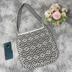 Detaillierte Nahaufnahme der schwarz-weißen geometrischen Stricktasche mit Textur.
