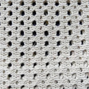 Nahaufnahme Detail von beige Strick hohl Mesh Stoff Textur, Premium gewebtes Material.