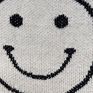 Detailansicht des gestrickten Smiley-Gesicht Musters einer Tragetasche, modischer Stil.