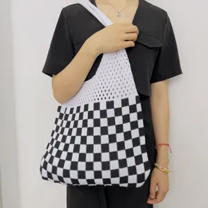 Borsa a tracolla in maglia a quadri bianchi e neri, vista dettagliata stile vintage casual.