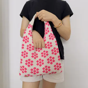 Nahaufnahme der geflochtenen Umhängetasche mit stilvollem rosa Blumenmuster und weicher Textur.