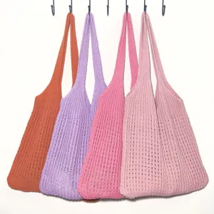 Detailansicht von bunten Strick Häkel Schulter Tote Taschen ordentlich an weißer Wand.