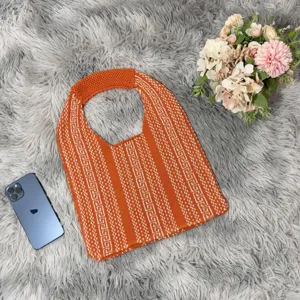 Close-up view of the orange and white geometric knitted shoulder tote bag texture.