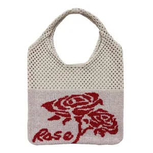 Detailansicht der gestrickten Netztasche mit gewebtem rotem Rosenmuster und Rose Text.