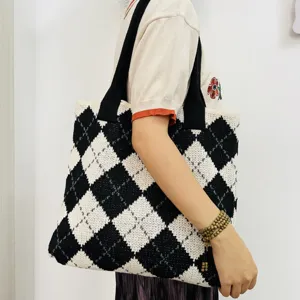 Detailed shot of a black and white argyle knitted tote bag worn on shoulder, stylish retro design.