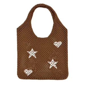 Braune gestrickte Shopper Tasche Detail mit Stern und Herz Muster und Netz Textur Design.