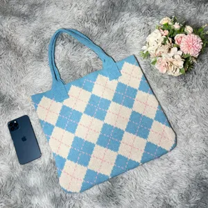 Close-up of blue argyle knit tote bag detail, soft fabric texture and aesthetic flat lay.