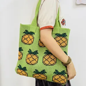 Green knitted tote bag featuring a cute pineapple pattern, perfect stylish shoulder bag.