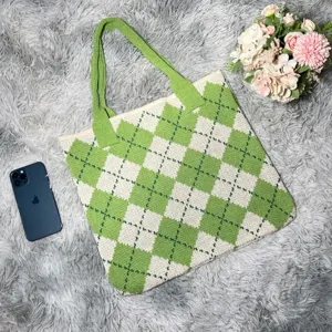 Green argyle knit tote bag detail view, showing soft woven fabric texture and pattern close up.