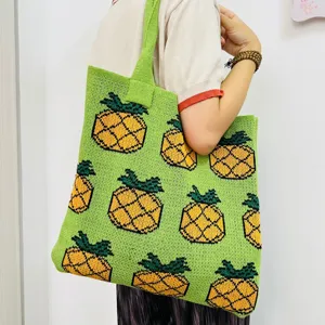Detailed view of the green knit tote bag featuring a cute retro pineapple pattern design.