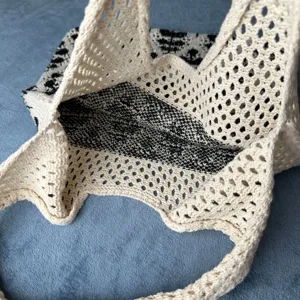 Nahaufnahme Detail einer stilvollen schwarz-weißen Häkelstrick-Hohltasche Schulter.
