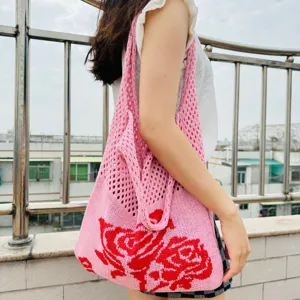 Rosa Strick-Tasche mit rotem Rosenmuster, Hohlwebdesign für lässigen und sommerlichen Alltag.