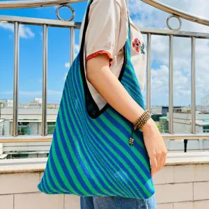 Dettaglio di una borsa shopper in maglia a righe blu e verdi, pratica borsa a spalla.