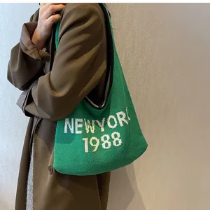Grüne Strick Umhängetasche Detailansicht mit New York 1988 Buchstaben und weicher Textur.