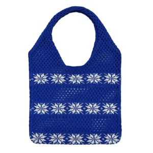 Nahaufnahme der blauen Strick-Tragetasche mit ausgearbeitetem weißen Schneeflocken-Muster.