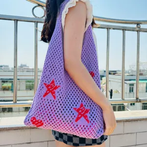Lila Stricknetz-Tragetasche mit roten Sternmustern, lässige Schultertasche Detailansicht.