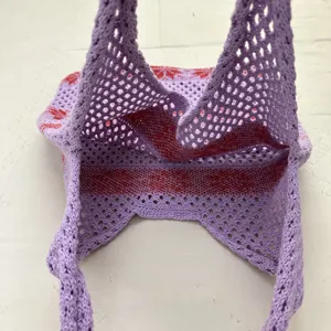 Nahaufnahme der lila gehäkelten Mesh-Tasche mit feinen Details und hohler Strickstruktur.