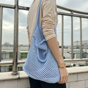 Detailansicht der hellblauen, gehäkelten Schultertasche mit hohlem Netzmuster für den Sommer.