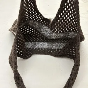 Detailansicht der dunkelbraunen Häkel-Strick-Schultertasche mit Netztextur und Trageriemen.