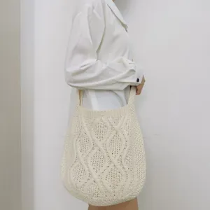 Gestrickte Umhängetasche Detailansicht mit weichem Zopfmuster und stabilem Trageriemen.