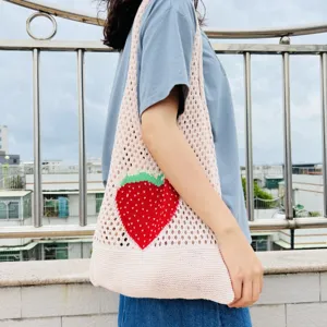 Detailansicht der Strick-Netz-Tasche, rosa Umhängetasche mit süßem Erdbeer-Muster.