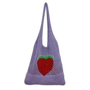 Detaillierte Nahaufnahme einer violetten Strick Netz Tasche mit rotem Erdbeer Motiv.