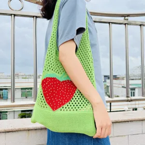 Detailansicht der grünen Strick-Tasche mit rotem Erdbeer-Muster, lässige Mesh Schultertasche.