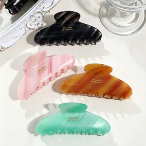 Minimalist acetate hair claw clip, elegant oval shark clip detail view in multiple colors.