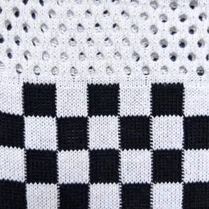Primo piano del tessuto della borsa lavorato a maglia a quadretti neri e bianchi, trama.