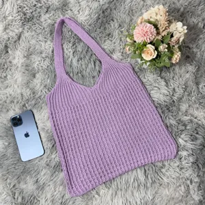 Lila geflochtene Tragetasche Detailansicht, lässige gewebte Schultertasche mit weichem Strickmuster.