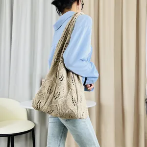 Detailansicht einer beigen, geflochtenen Strick-Schultertasche, getragen vom Model.