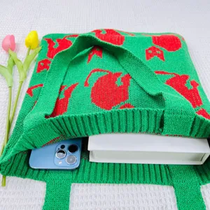Detailansicht der grünen Strick-Totetasche mit rotem Katzenmuster und weicher Stofftextur.