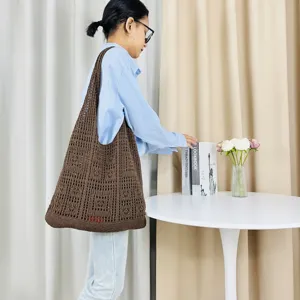 Detailaufnahme der braunen Stricktasche mit Lochmuster zeigt feine Häkelstruktur und große Kapazität.