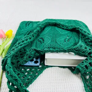 Detailansicht der einfarbigen grünen Strick-Häkel-Tasche mit modernem Lochmuster-Design.