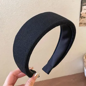 Close-up detail of a classic black ribbed wide headband, showcasing its fine knit texture.