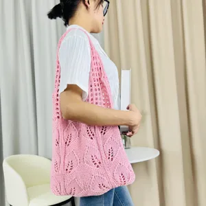 Detailansicht der rosa gestrickten Hohl-Tragetasche, die das zarte Blattmuster zeigt.