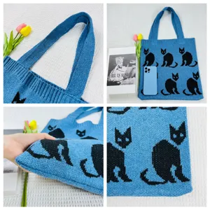 Nahaufnahme der blauen Strick-Tote-Bag mit süßem schwarzem Katzenmuster und weichem Stoff.