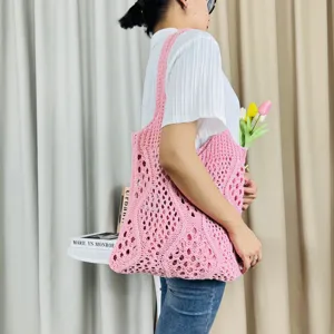 Rosa ausgehöhlte Strick-Tasche im Detail, lässige gewebte Schultertasche für Strand und Alltag.
