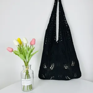 Nahaufnahme einer schwarzen, hohlen Strick-Schultertasche mit einzigartiger Webtextur.