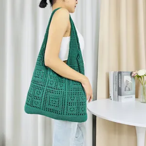 Detailansicht der dunkelgrünen Strick-Hohltasche in einer stilvollen Alltagsszene.