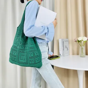 Detailansicht der dunkelgrünen gestrickten Tasche mit ihrer feinen gewebten Netztextur.